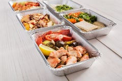 Healthy food take away in foil boxes on wood background royalty free stock photography Healthy food take away in foil boxes on wood background royalty free stock photography
