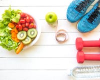 Healthy lifestyle for women diet with sport equipment, sneakers, measuring tape, vegetable fresh, green apples and bottle of water
