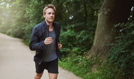 Healthy Man in Jacket Jogging at the Park royalty free stock photo Healthy Man in Jacket Jogging at the Park royalty free stock photo