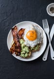 Healthy nutritious breakfast - avocado toast, bacon and fried egg on dark background royalty free stock photography Healthy nutritious breakfast - avocado toast, bacon and fried egg on dark background royalty free stock photography