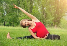 Healthy pregnant woman doing yoga in nature
