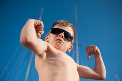 Healthy preschool child showing his biceps outdoors summer stock photo Healthy preschool child showing his biceps outdoors summer stock photo