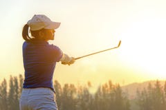 Healthy Sport. Asian Sporty woman golfer player doing golf swing tee off on the green evening time, she presumably does exercise. royalty free stock images Healthy Sport. Asian Sporty woman golfer player doing golf swing tee off on the green evening time, she presumably does exercise. royalty free stock images