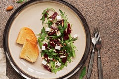 Healthy vegan diet salad with beetroot, arugula, feta cheese, nuts and seeds over brown stone background. Top view, flat lay stock photos Healthy vegan diet salad with beetroot, arugula, feta cheese, nuts and seeds over brown stone background. Top view, flat lay stock photos