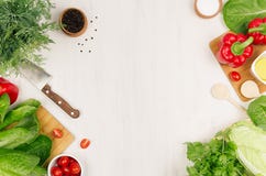 Healthy vegetarian ingredients for spring fresh green salad and kitchenware on white wood board, top view, copy space. royalty free stock image Healthy vegetarian ingredients for spring fresh green salad and kitchenware on white wood board, top view, copy space. royalty free stock image