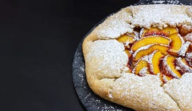 Healthy wholewheat galette with peaches nectarines. Black background. stock image Healthy wholewheat galette with peaches nectarines. Black background. stock image