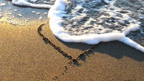 Heart drawn on the beach sand