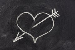 Heart pierced by arrow, love symbol on blackboard stock photos Heart pierced by arrow, love symbol on blackboard stock photos