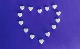Heart shaped tablets on purple background stock photos Heart shaped tablets on purple background stock photos