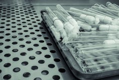 Many of Heat-resistant glass biological test tubes with cotton plug on a metal tray stock photography Many of Heat-resistant glass biological test tubes with cotton plug on a metal tray stock photography