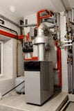 Heating of the house with a large number of steel pipes, pressure gauges and metal pipes, selective focus. Boiler and pipes of the stock image Heating of the house with a large number of steel pipes, pressure gauges and metal pipes, selective focus. Boiler and pipes of the stock image