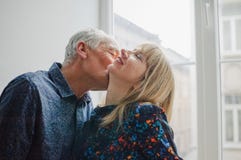 Hei?e und sexy Frau von mittlerem Alter, die das K?ssen ihres ?lteren Ehemanns steht nahe ge?ffnetem Fenster innerhalb ihres Haus stockbilder Hei?e und sexy Frau von mittlerem Alter, die das K?ssen ihres ?lteren Ehemanns steht nahe ge?ffnetem Fenster innerhalb ihres Haus stockbilder