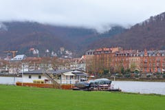 Boat permanently anchored at the Neckar river meadow near city center of Heidelberg, with old buildings and beautiful hill landsca stock images Boat permanently anchored at the Neckar river meadow near city center of Heidelberg, with old buildings and beautiful hill landsca stock images