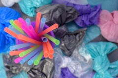 Heldere multi-colored plastic buisjes in een purper glas op de achtergrond van vuilniszakken royalty-vrije stock fotografie Heldere multi-colored plastic buisjes in een purper glas op de achtergrond van vuilniszakken royalty-vrije stock fotografie