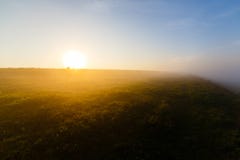 Heldere zon die bij de horizon over mistige hellingen glanzen royalty-vrije stock afbeelding Heldere zon die bij de horizon over mistige hellingen glanzen royalty-vrije stock afbeelding