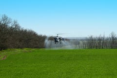 Helicóptero com pulverizador acima do campo agrícola na exploração agrícola na mola imagem de stock Helicóptero com pulverizador acima do campo agrícola na exploração agrícola na mola imagem de stock