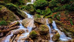 Heller saftiger Wasserfall im Herbstwald lizenzfreie stockbilder Heller saftiger Wasserfall im Herbstwald lizenzfreie stockbilder