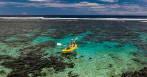 Hembra y niño pequeño que baten la canoa en una laguna tropical metrajes Hembra y niño pequeño que baten la canoa en una laguna tropical metrajes
