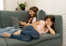 Hemfallen ung flicka f?r internet som anv?nder b?rbara datorn som ignorerar hennes ledsna ensamma mer unga syster royaltyfria bilder Hemfallen ung flicka f?r internet som anv?nder b?rbara datorn som ignorerar hennes ledsna ensamma mer unga syster royaltyfria bilder