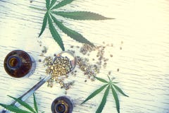 Hemp leaves on wooden background, seeds, cannabis oil extracts in jars Stock Image Hemp leaves on wooden background, seeds, cannabis oil extracts in jars Stock Image