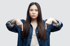 Here and right now. Portrait of serious bossy beautiful brunette asian young woman in casual blue denim jacket with makeup stock image Here and right now. Portrait of serious bossy beautiful brunette asian young woman in casual blue denim jacket with makeup stock image