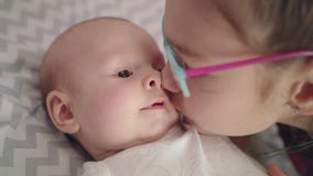 Hermana que besa al bebé Ciérrese para arriba de la muchacha que besa al bebé recién nacido Hermano del beso de la hermana almacen de metraje de vídeo Hermana que besa al bebé Ciérrese para arriba de la muchacha que besa al bebé recién nacido Hermano del beso de la hermana almacen de metraje de vídeo