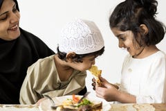 Hermano feeing de la hermana en una cena de la familia imagenes de archivo Hermano feeing de la hermana en una cena de la familia imagenes de archivo