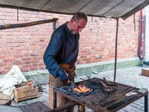 Herrero que trabaja en el mercado medieval de los artes imágenes de archivo libres de regalías Herrero que trabaja en el mercado medieval de los artes imágenes de archivo libres de regalías