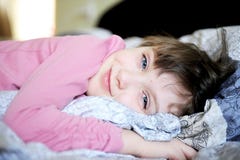 Het aanbiddelijke meisje ontspannen in bed stock foto Het aanbiddelijke meisje ontspannen in bed stock foto