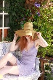 Het aantrekkelijke rode haired vrouw ontspannen in tuin royalty-vrije stock fotografie Het aantrekkelijke rode haired vrouw ontspannen in tuin royalty-vrije stock fotografie