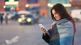 Het aantrekkelijke slimme vrij jonge mooie meisje die de telefoon onttrekken en in de stedelijke straat glimlachen met unfocused stock video Het aantrekkelijke slimme vrij jonge mooie meisje die de telefoon onttrekken en in de stedelijke straat glimlachen met unfocused stock video