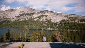 Het achtermeisje die van de menings gelukkige opgewekte toerist met rugzak verbazend het panorama van het bergmeer bij Yosemite-p stock videobeelden Het achtermeisje die van de menings gelukkige opgewekte toerist met rugzak verbazend het panorama van het bergmeer bij Yosemite-p stock videobeelden