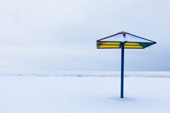 Het alleen zonnescherm of de parasol op het de winterstrand onder de sneeuw stock afbeeldingen Het alleen zonnescherm of de parasol op het de winterstrand onder de sneeuw stock afbeeldingen