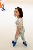 Het Aziatische meisje op de het schaatsen piste in blauwe schaatsen, glimlacht gelukkig het leuke ijs van het kindspel schaatsend royalty-vrije stock foto's Het Aziatische meisje op de het schaatsen piste in blauwe schaatsen, glimlacht gelukkig het leuke ijs van het kindspel schaatsend royalty-vrije stock foto's
