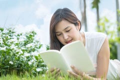 Het Aziatische vrouw liggen op grasgebied voor las een wit boek in het park, ontspanningsconcept door mooie Aziatische vrouw Royalty-vrije Stock Afbeelding Het Aziatische vrouw liggen op grasgebied voor las een wit boek in het park, ontspanningsconcept door mooie Aziatische vrouw Royalty-vrije Stock Afbeelding