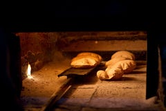 Het baksel van het brood in een open traditionele brandhoutoven stock foto's Het baksel van het brood in een open traditionele brandhoutoven stock foto's