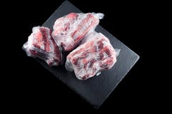 Het bevroren vlees in een plastic zak op een steentribune op een zwarte achtergrond, isoleert royalty-vrije stock afbeeldingen Het bevroren vlees in een plastic zak op een steentribune op een zwarte achtergrond, isoleert royalty-vrije stock afbeeldingen
