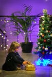 Het blondemeisje bereidt en zet giften onder de Kerstboom voor stock afbeelding Het blondemeisje bereidt en zet giften onder de Kerstboom voor stock afbeelding