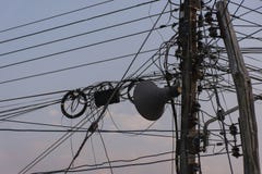 Het chaotische Ineenstrengelen knoeit van de lijnen van de elektriciteitsmacht op pool stock afbeeldingen Het chaotische Ineenstrengelen knoeit van de lijnen van de elektriciteitsmacht op pool stock afbeeldingen
