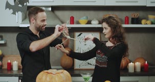 Het charismatische paar bij Halloween-nacht het spelen met een skelet, heeft samen een grappige tijd stock videobeelden Het charismatische paar bij Halloween-nacht het spelen met een skelet, heeft samen een grappige tijd stock videobeelden