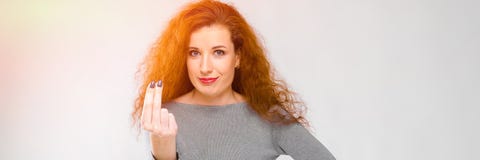 Het charmeren van jong meisje met rood haar Een jong meisje in een grijze sweater Jong meisje op een grijze achtergrond Het jonge stock foto Het charmeren van jong meisje met rood haar Een jong meisje in een grijze sweater Jong meisje op een grijze achtergrond Het jonge stock foto