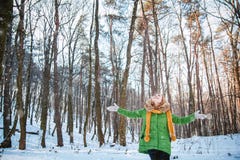 Het cijfer van een meisje in een parka, hoed die, pluizige vuisthandschoenen, zich met uitgestrekte wapens bevinden, die de zon i stock afbeeldingen Het cijfer van een meisje in een parka, hoed die, pluizige vuisthandschoenen, zich met uitgestrekte wapens bevinden, die de zon i stock afbeeldingen