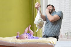 Het concept van de babyzorg Vaderod de papa verandert stinky luier royalty-vrije stock foto Het concept van de babyzorg Vaderod de papa verandert stinky luier royalty-vrije stock foto