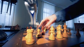 Het concept van de kunstmatige intelligentie Innovatief modern robotachtig wapen het spelen schaak met een mens 4K Het concept van de kunstmatige intelligentie Innovatief modern robotachtig wapen het spelen schaak met een mens 4K