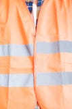 Het concept van de veiligheidsbouw met oranje beschermingsvest in het sluiten royalty-vrije stock afbeeldingen Het concept van de veiligheidsbouw met oranje beschermingsvest in het sluiten royalty-vrije stock afbeeldingen