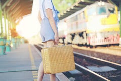 Het concept van de de zomervakantie, Close-up van vrouw die bruine natuurlijke rieten zak houden bij station op het licht Modieuz stock foto Het concept van de de zomervakantie, Close-up van vrouw die bruine natuurlijke rieten zak houden bij station op het licht Modieuz stock foto
