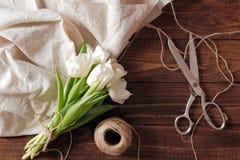 Het de lenteboeket van witte tulp bloeit, lege document kaart, schaar, streng op rustiek houten bureau De de dagsamenstelling van royalty-vrije stock foto's Het de lenteboeket van witte tulp bloeit, lege document kaart, schaar, streng op rustiek houten bureau De de dagsamenstelling van royalty-vrije stock foto's