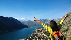 Het donkerbruine meisje bevindt zich bovenop een berg en het kijken in de richting van Baai boko-Kotor aan Kotor in Montenegro re stock afbeeldingen Het donkerbruine meisje bevindt zich bovenop een berg en het kijken in de richting van Baai boko-Kotor aan Kotor in Montenegro re stock afbeeldingen
