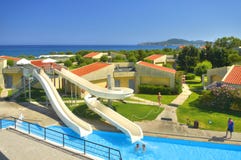 HET EILAND VAN RHODOS, GRIEKENLAND, JUN 22, 2013: De mening van de Koninklijke villa's van Grecotel Rhodos, zwembadwater glijdt, royalty-vrije stock afbeeldingen HET EILAND VAN RHODOS, GRIEKENLAND, JUN 22, 2013: De mening van de Koninklijke villa's van Grecotel Rhodos, zwembadwater glijdt, royalty-vrije stock afbeeldingen
