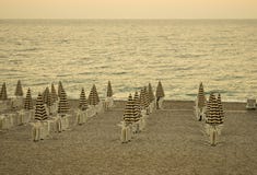 Het gelijk maken van leeg strand met stoelen en gestreepte paraplu's Toevluchtlandschap Uitstekende retro filter stock foto Het gelijk maken van leeg strand met stoelen en gestreepte paraplu's Toevluchtlandschap Uitstekende retro filter stock foto